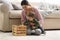 Young nanny and cute baby playing with toys at home