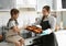 Young nanny with cute little girl cooking together