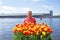 Young native dutch woman smelling blossoming tulips in the harbor from Amsterdam