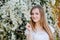 Young naturally beautiful woman near the blooming tree in spring time