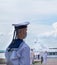 A young navy sailor in a medical mask stands in service during a rehearsal of the naval parade