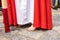 A young Nazarene or penitent with white and red clothes is doing his penance station with bare feet in the Holy Week procession