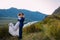 Young newly wed couple, bride and groom kissing, hugging on perfect view of mountains, blue sky