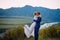 Young newly wed couple, bride and groom kissing, hugging on perfect view of mountains, blue sky