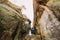 Young newlywed couple posing in weathered rock cleft holding hands together