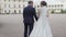 Young newlyweds walking outside. The bride and groom walk together in the Park in winter or summer and holding hands