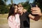 Young nice couple standing and making selfie in park