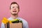 A young nice guy in eyeglasses stands on a pink background with a cardboard box like dismissal