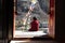 Young Novice Monk Sitting Outside Buddhist Temple