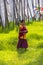 Young novice monk walks in meadow , Bhutan