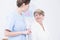 Young nurse and elder woman in bright hospital corridor