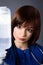 A young nurse uses a dropper couper with medicine. Brunette girl posing on a gray background