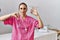 Young nurse woman at political campaign holding usa vote badge with angry face, negative sign showing dislike with thumbs down,