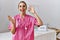 Young nurse woman at political campaign holding usa vote badge celebrating victory with happy smile and winner expression with