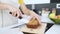 Young nutritionist hands cutting carrot cake into small pieces in the kitchen at home.