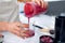 Young nutritionist woman serving healthy handmade smoothie in a cup in kitchen at home