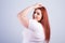 Young obese woman in casual clothes on a white background in the studio. Bodypositive and improper nutrition.