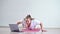 A young obese woman does push-ups. The girl is engaged in fitness at home on the mat and watches a training video on a