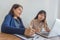 Young office ladies working on laptop during business discussion