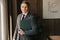 A young office worker with fair skin holds a folder with documents in his hands, stands in his office. The man works in the office