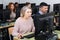 Young and older businesswomen and businessmen in open plan office