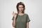 Young optimistic woman with curly hair demonstrates okay sign