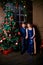 Young ordinary family of two. Young husband and wife near christmas tree. Happy young hetero couple decorate christmas tree at