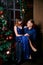 Young ordinary family of two. Young husband and wife near christmas tree. Happy young hetero couple decorate christmas tree at