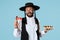 The young orthodox Jewish man with black hat with Hamantaschen cookies for Jewish festival of Purim