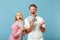 Young overjoyed couple two friends guy girl in white pink t-shirts posing isolated on pastel blue background. People