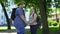 Young overweight man and woman holding hands and nuzzling in park, students love