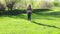 Young overweight woman in fitness suit tilt head from side to side standing on green lawn in park on sunny day, nature