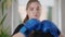 Young overweight woman looking at camera boxing shadow. Portrait of concentrated focused Caucasian female boxer training