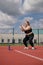 Young overweight woman in sportive clothes is exercising outdoors.