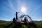 Young pair in tent on mountain holiday under the bright sun in the blue sky