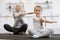 Young parent and daughter in sportswear spend time happily during workout.