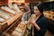 Young parents and daughter in grocery store. Cheerful woman smell bread she hold in hands. Father stand behind with