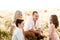 Young parents with their son and daughter are sitting in a daisy field