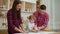 Young parents with toddler daughter have fun together kneading dough