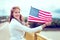 Young patriot woman with toothy smile showing stretched USA flag