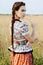 Young peasant woman, dressed in Hungarian national costume, posing over nature background