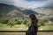 Young pensive woman with closed eyes stands on the background of mountains