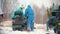 Young people in bright clothes getting the snowmobile ready