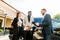 Young People business couple African man and Caucasian woman standing outdoors in a Car Rental Service, talking with