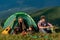 Young people on camping trip. Healthy lifestyle and eco tourism. Group of happy friends in tent eating summer fruits at