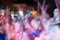 Young people crowd dancing and cheering during a rock band music concert performance at a festival