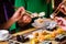 Young people eating sushi in restaurant