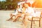 Young people enjoying summer vacation sunbathing drinking at beach bar