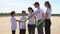 Young people family recycle plastic bottle talking and shaking hands while standing on beach on summer day spbi.