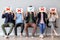 Young people holding paper sheets with different marks while sitting on chairs indoors. Job interview concept